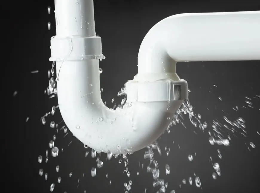 Fuga de agua goteando en una tubería de desagüe antes de la reparación
